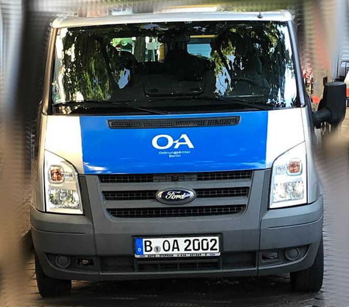 blau-silber Ford-Transporter von vorne, auf der Motorhaube steht OA