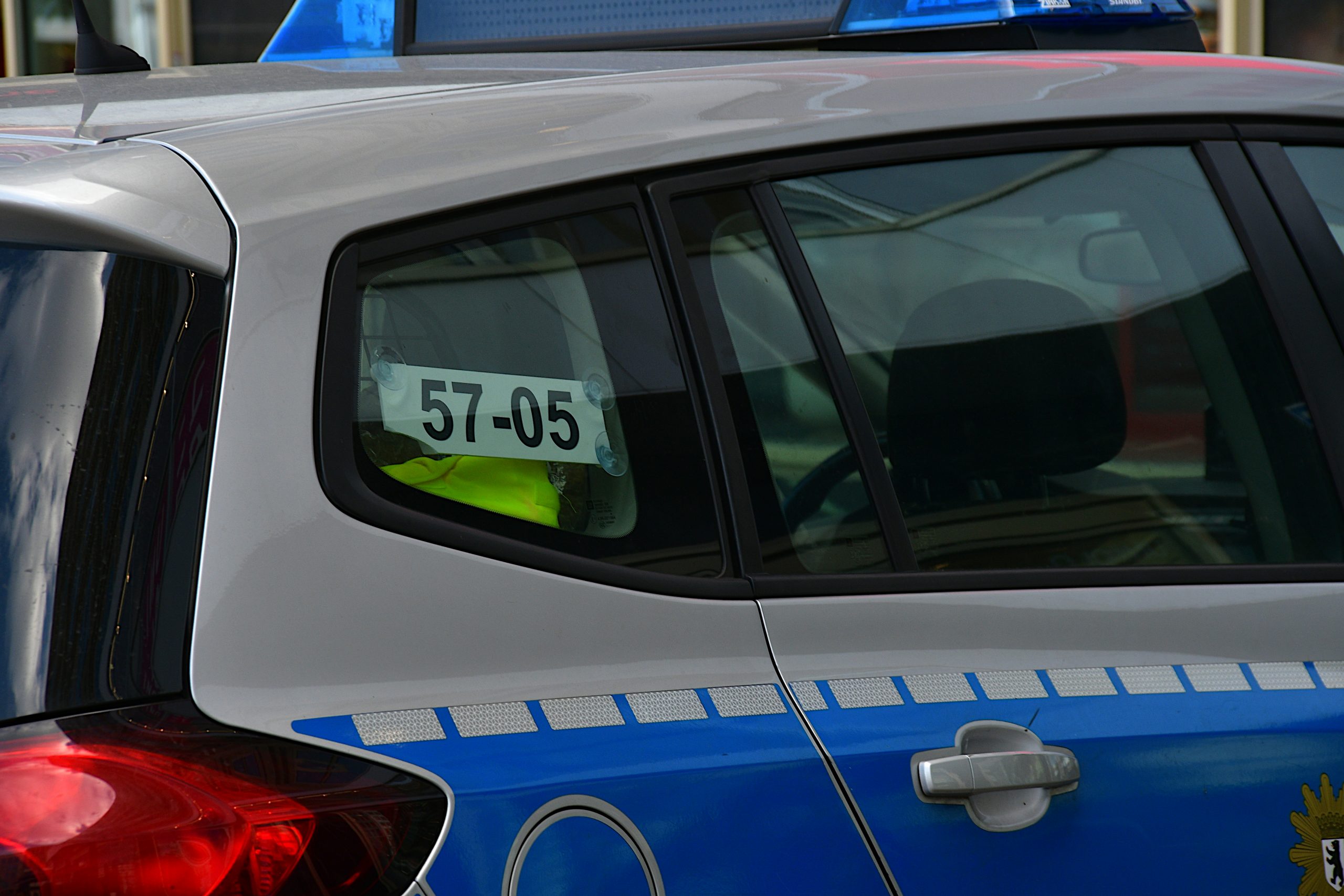 Ein silber-blaues Polizeiauto, im hinteresten Fenster ist die Funkkennung 57-05 angebracht.